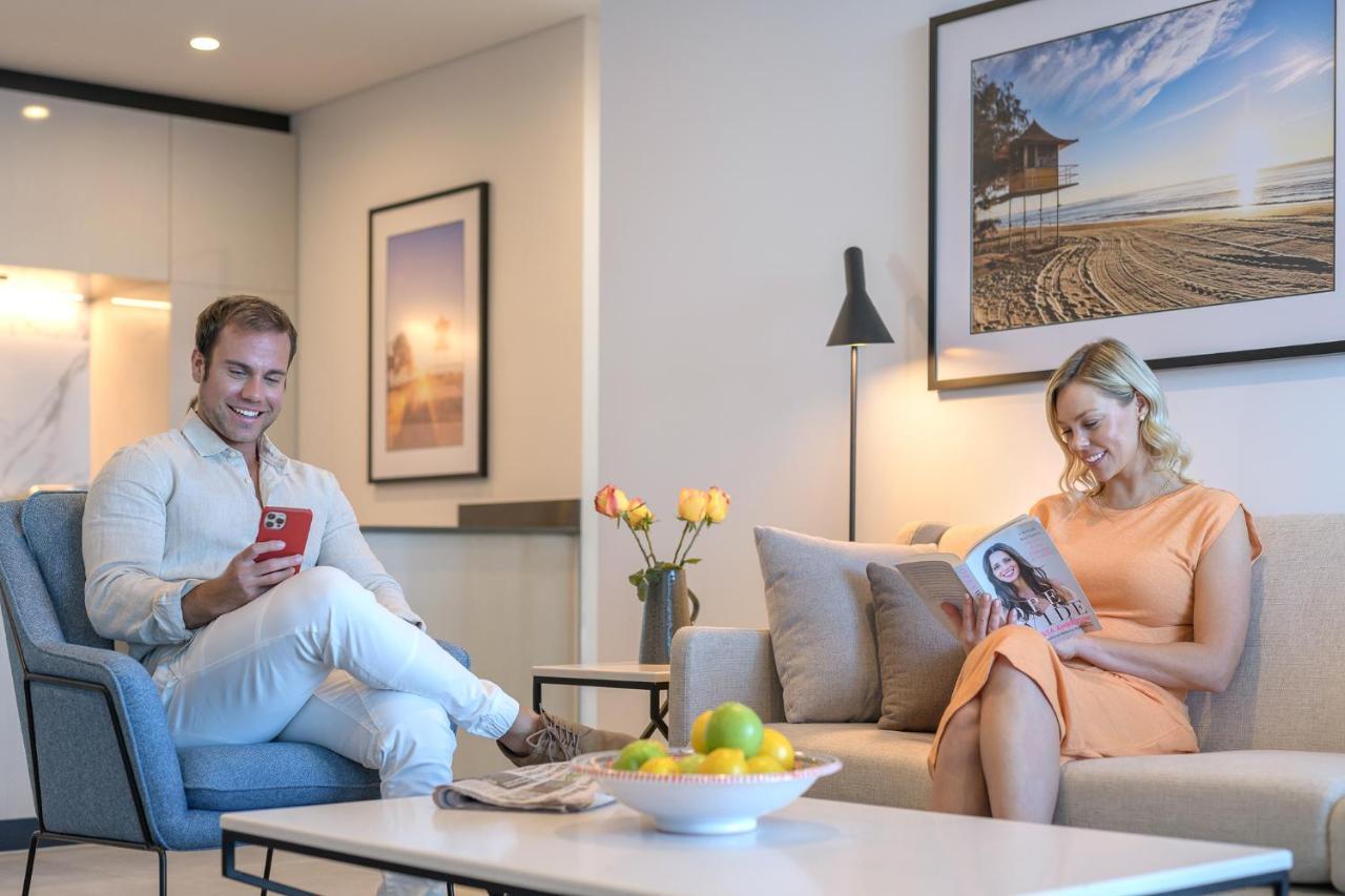 Meriton Suites Surfers Paradise Gold Coast Buitenkant foto A couple reading a magazine in their living room